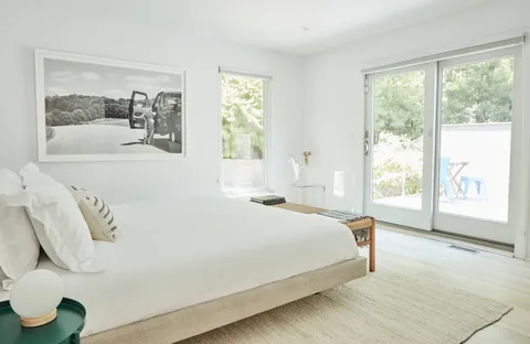 a bedroom with a large bed and a large window with the outer view