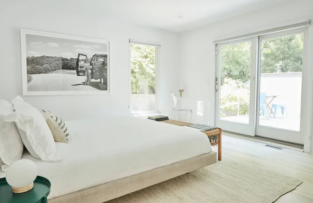 a bedroom with a large bed and a large window with the outer view