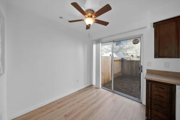 a view of an empty room with a fireplace and a fan