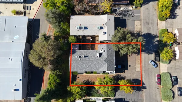 aerial view of a house with a yard and a bench
