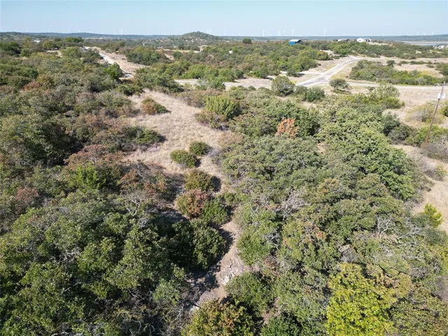 an aerial view of residential houses with outdoor space and trees