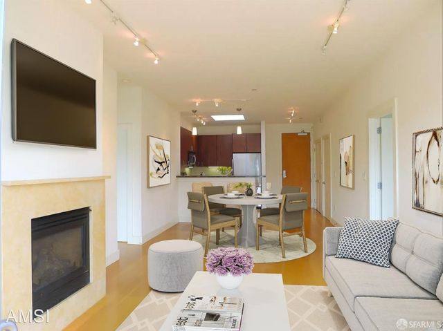 a living room with furniture a flat screen tv and a fireplace