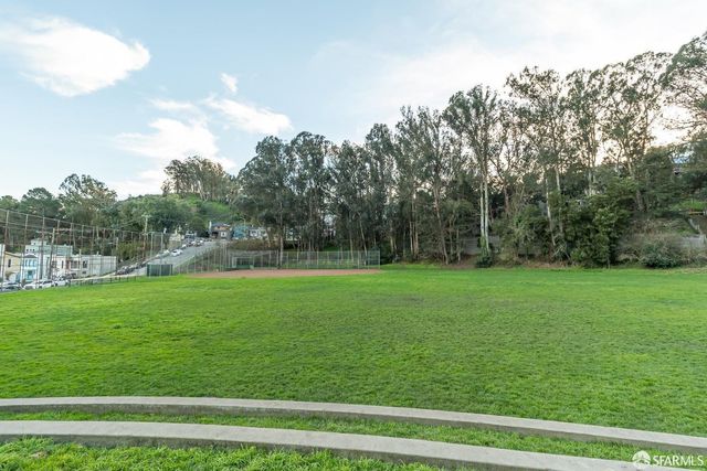 a view of a green field with wooden fence