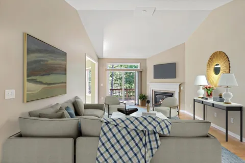 a living room with furniture a fireplace and a flat screen tv