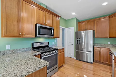 a kitchen with granite countertop a refrigerator stove and microwave
