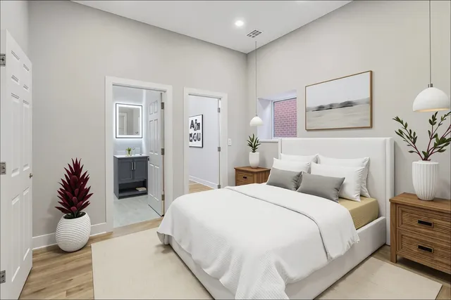 a bedroom with a bed and a potted plant