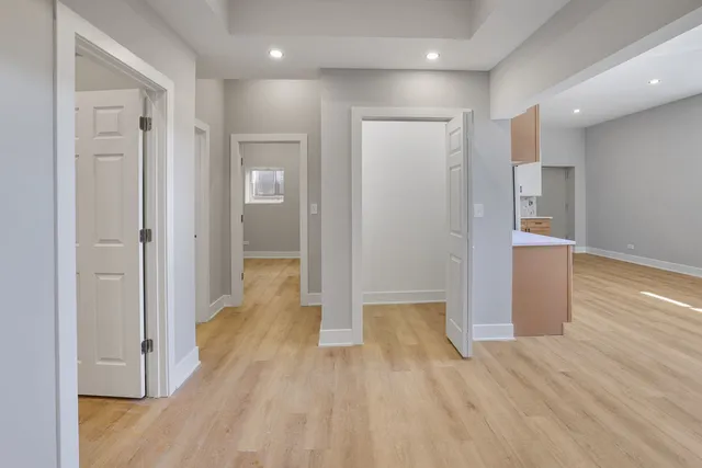 a view of a hallway with wooden floor and closet area