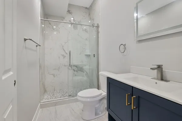 a bathroom with a sink a toilet and shower