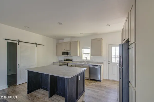 a kitchen with kitchen island a sink appliances and cabinets
