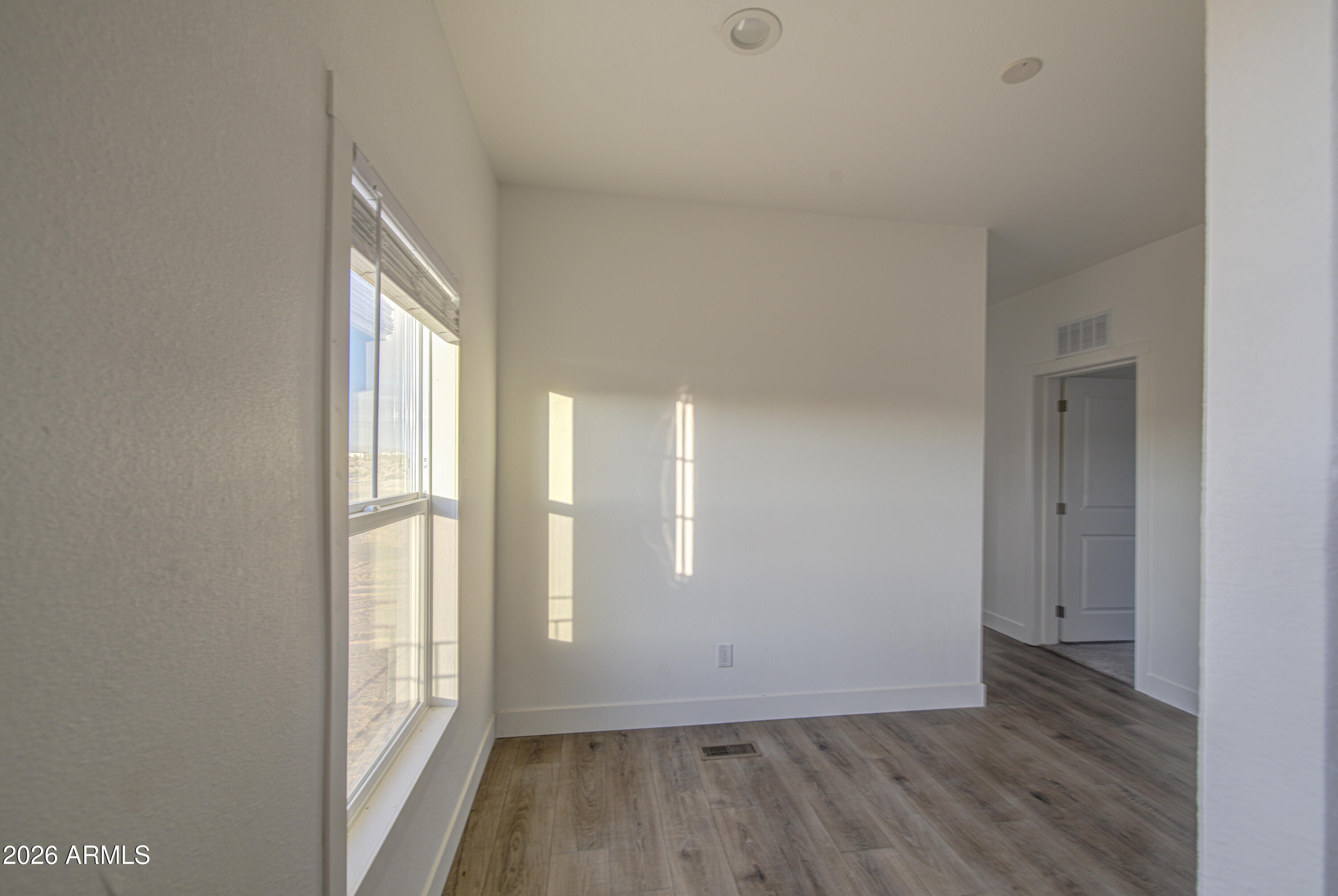 39112 West Maldonado Road Tonopah, AZ 85354 - Photo 8 of 34 an empty room with wooden floor and windows