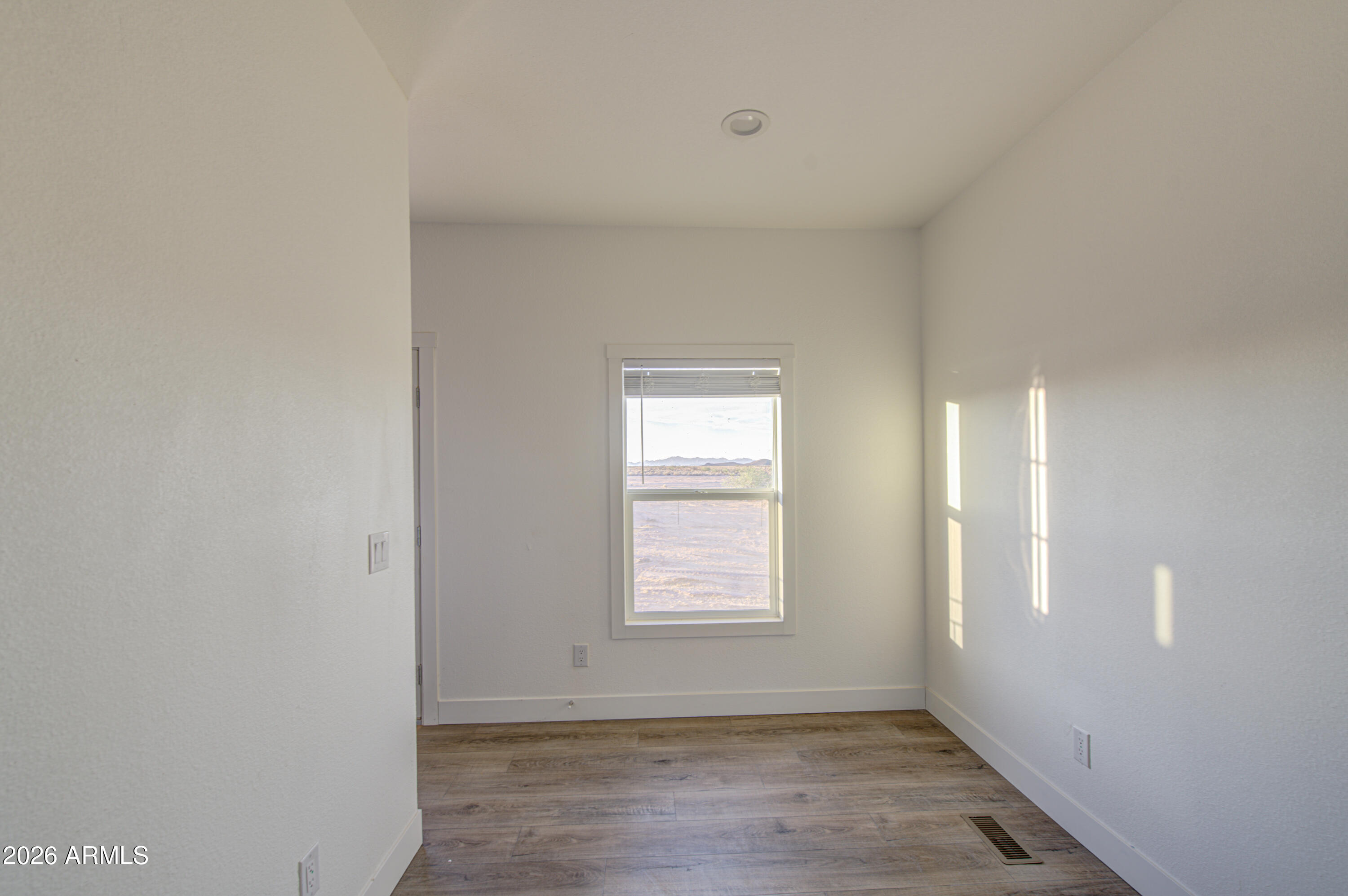39112 West Maldonado Road Tonopah, AZ 85354 - Photo 10 of 34 a view of an empty room with wooden floor and a window