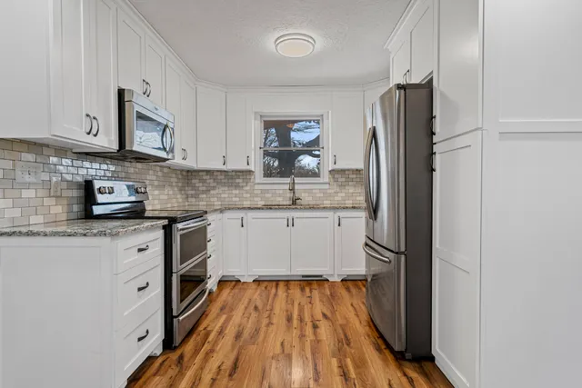 a kitchen with stainless steel appliances granite countertop a refrigerator sink and stove