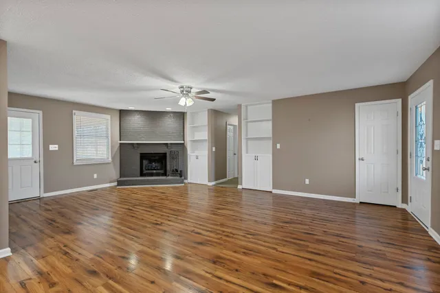 a view of empty room with wooden floor and fireplace