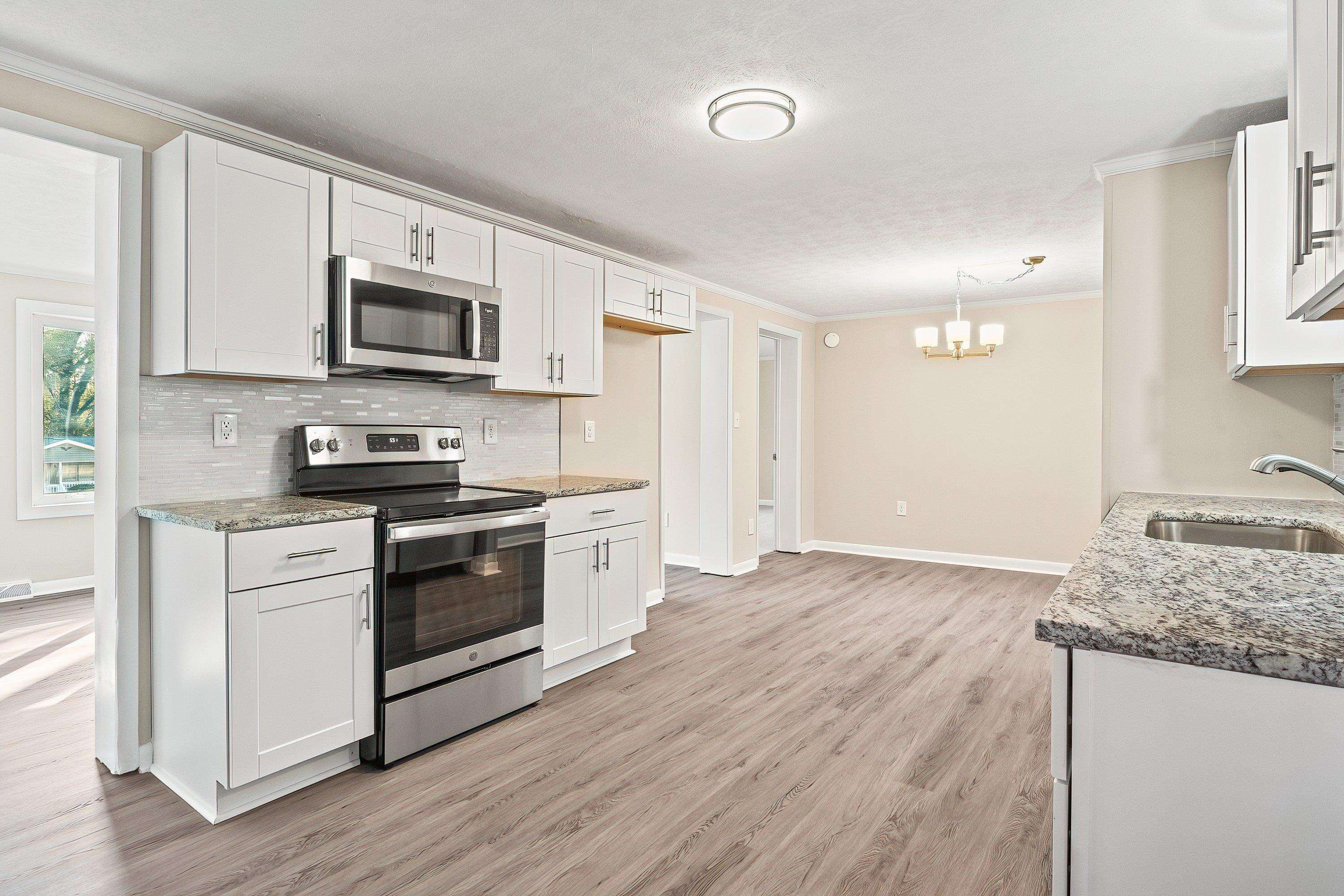 1313 Ewing Drive Garner, NC 27529 - Photo 11 of 46 a kitchen with stainless steel appliances granite countertop a stove a sink and a microwave