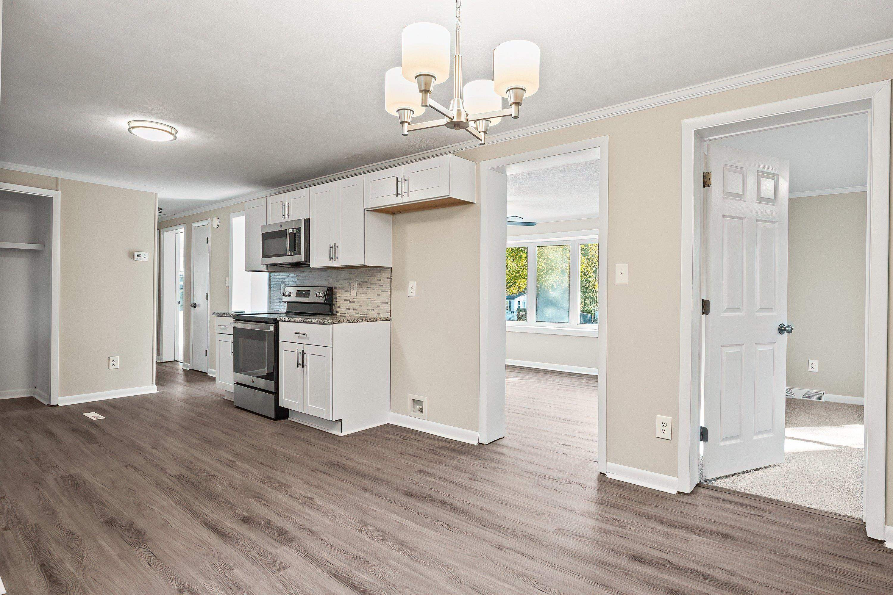 1313 Ewing Drive Garner, NC 27529 - Photo 12 of 46 a view of a kitchen with wooden floor and a refrigerator