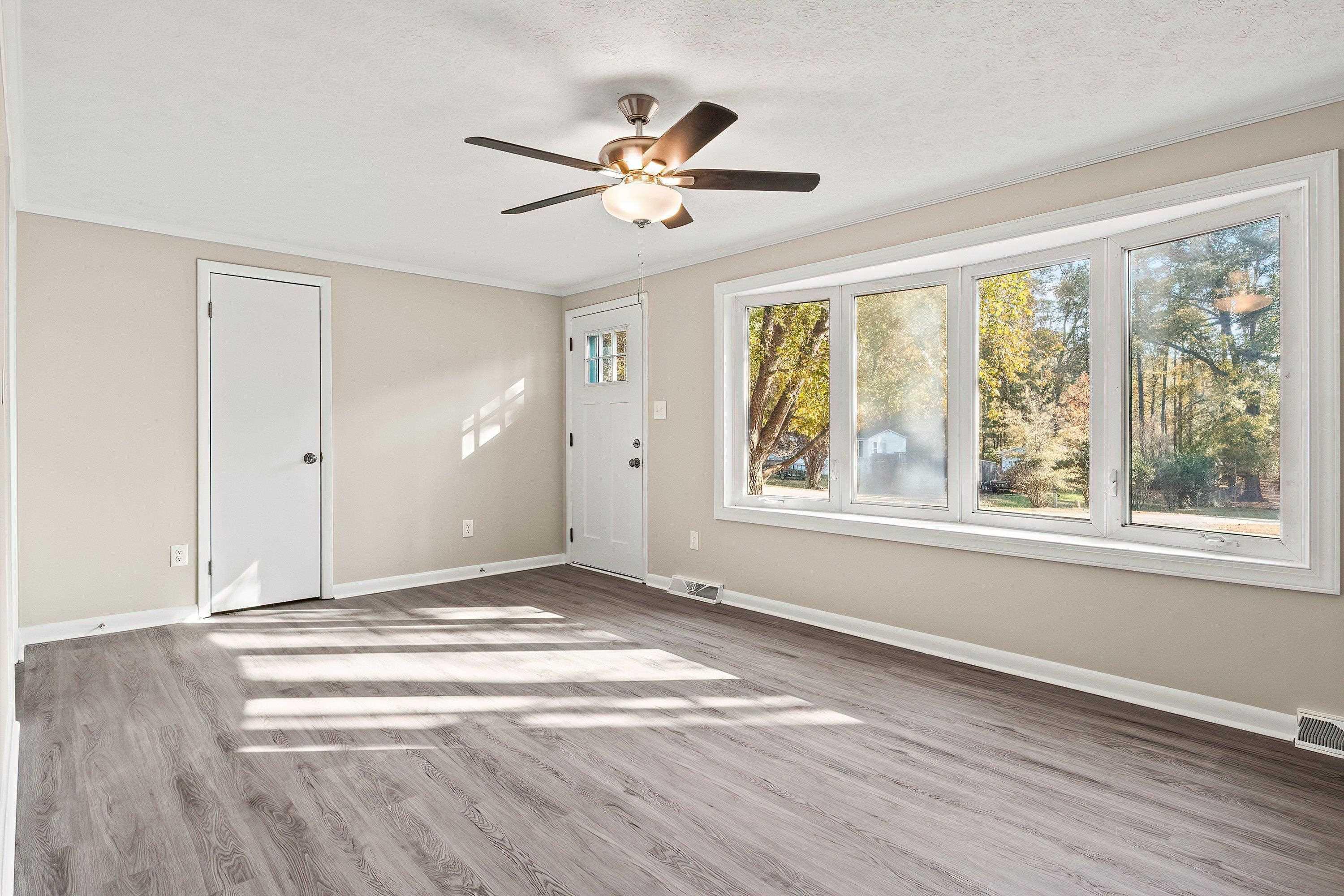 1313 Ewing Drive Garner, NC 27529 - Photo 14 of 46 a view of empty room with wooden floor and fan