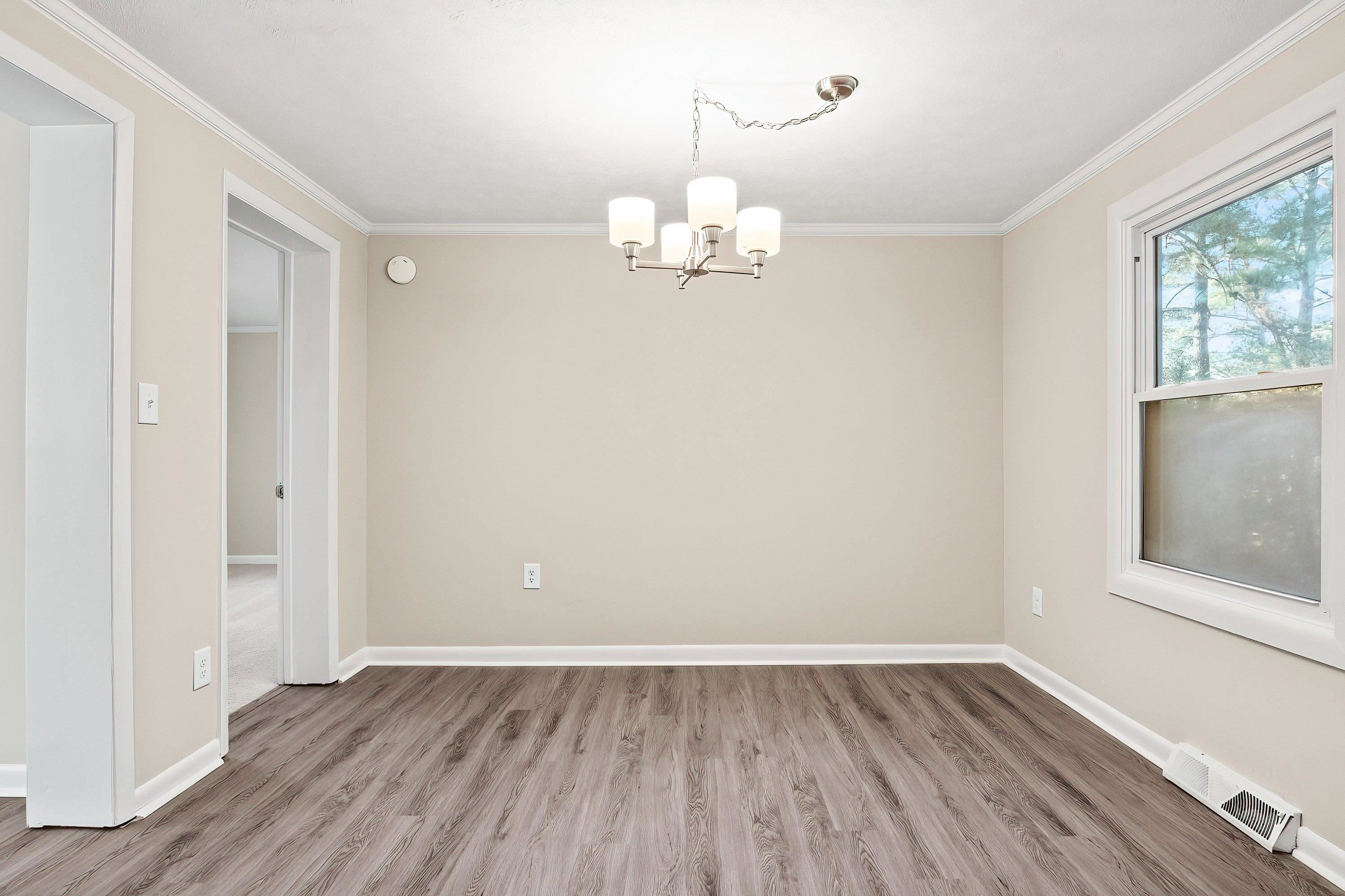 1313 Ewing Drive Garner, NC 27529 - Photo 16 of 46 an empty room with wooden floor and windows