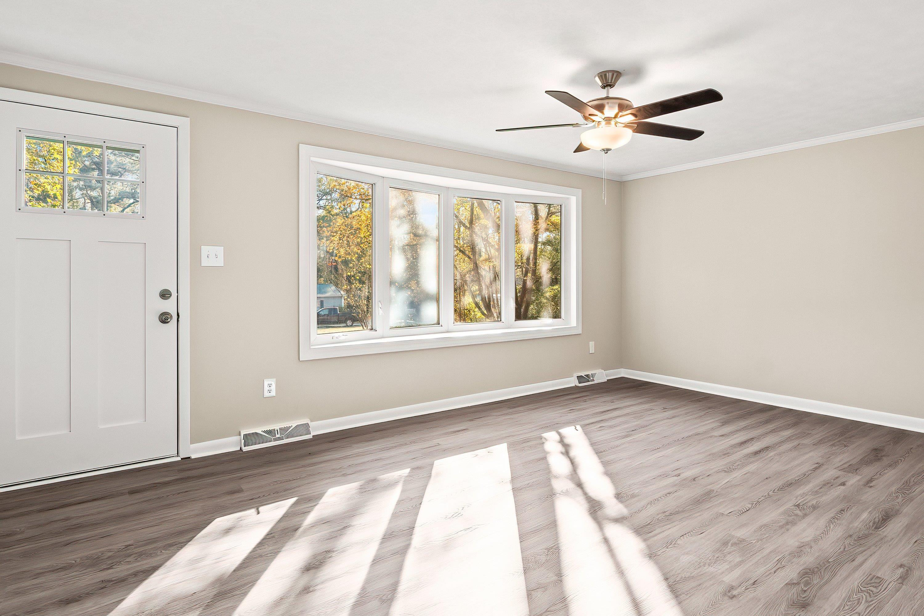 1313 Ewing Drive Garner, NC 27529 - Photo 19 of 46 a view of an empty room with wooden floor and a window