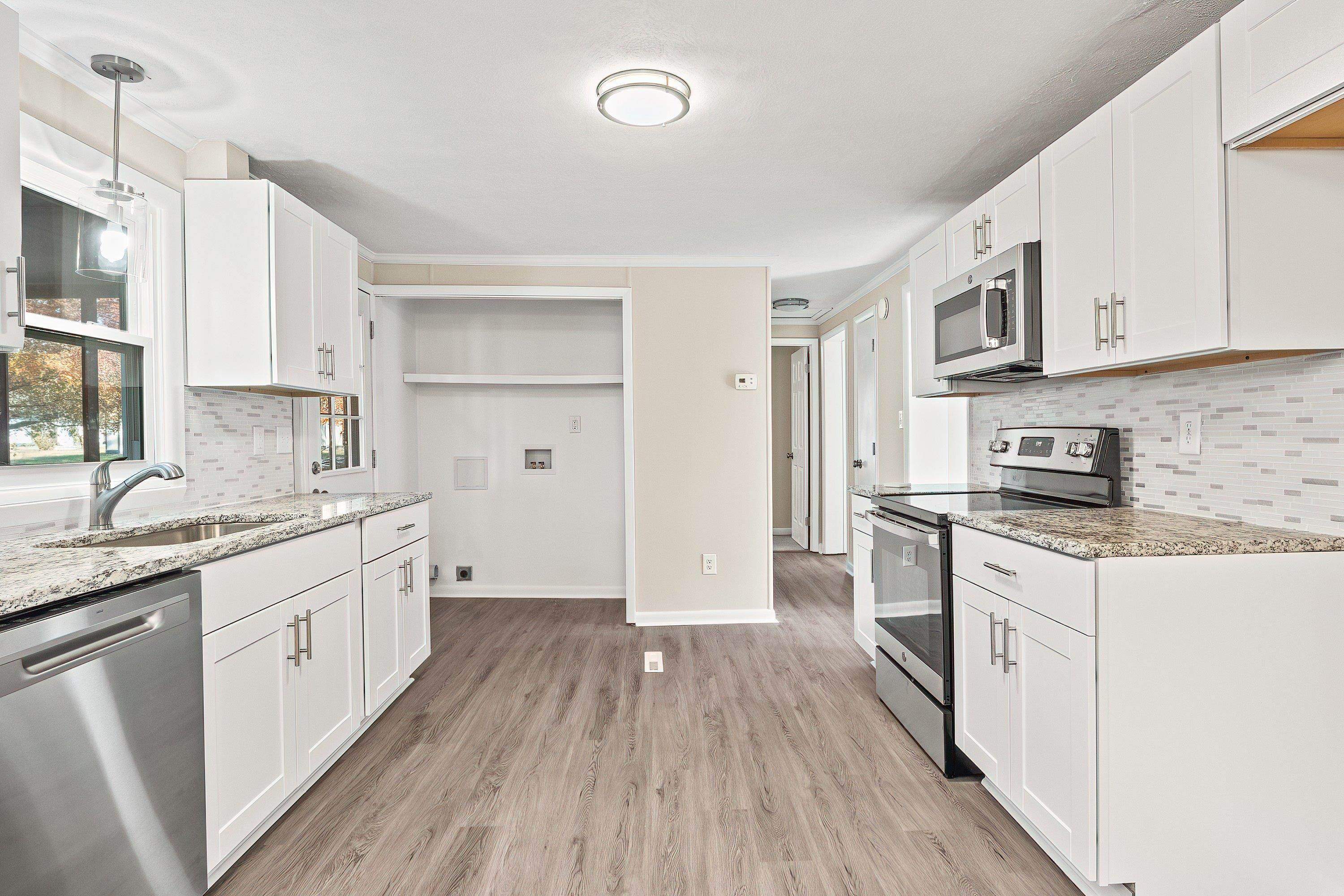 1313 Ewing Drive Garner, NC 27529 - Photo 2 of 46 a large kitchen with stainless steel appliances granite countertop a lot of counter space and wooden floors