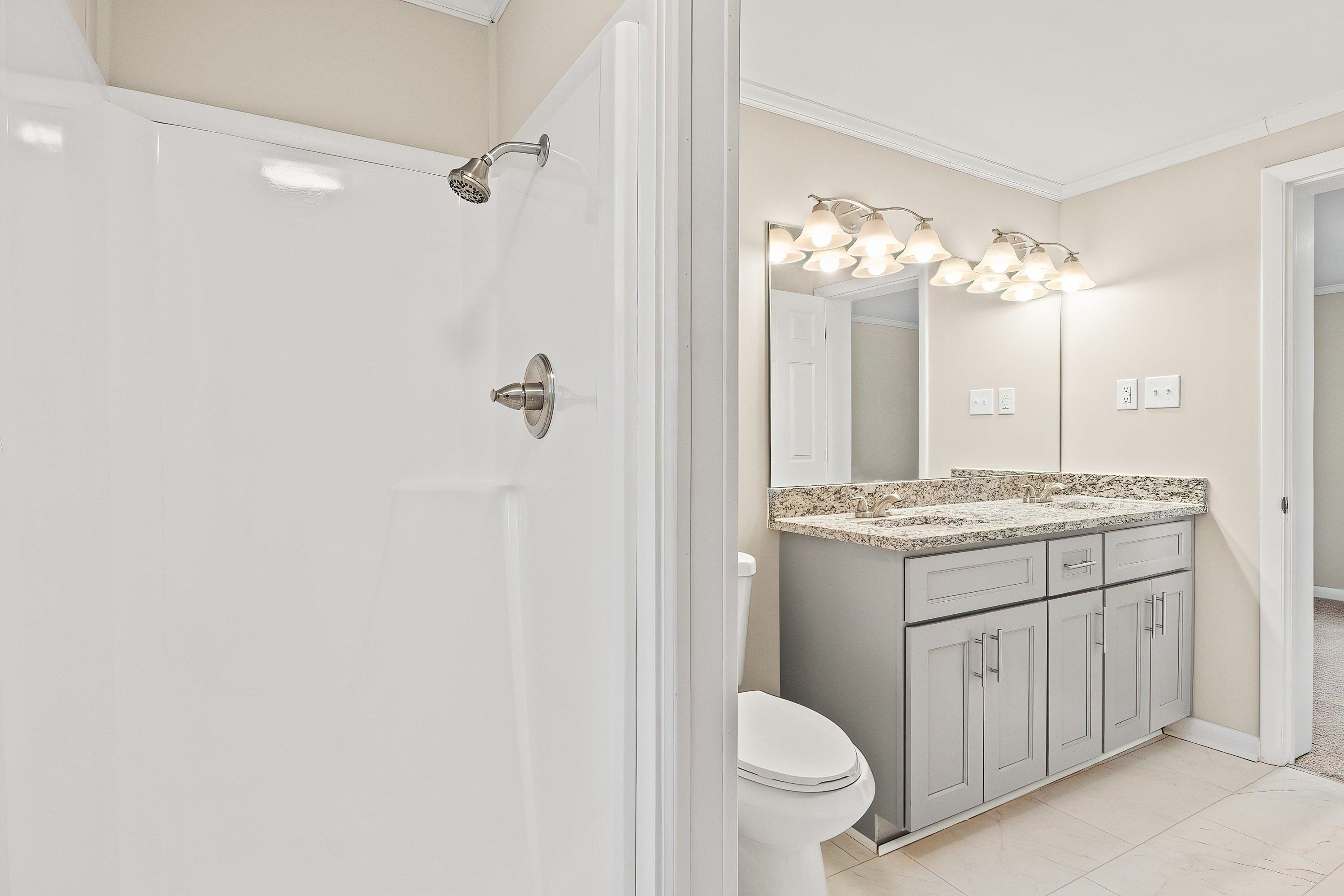 1313 Ewing Drive Garner, NC 27529 - Photo 32 of 46 a bathroom with a granite countertop sink a toilet and shower