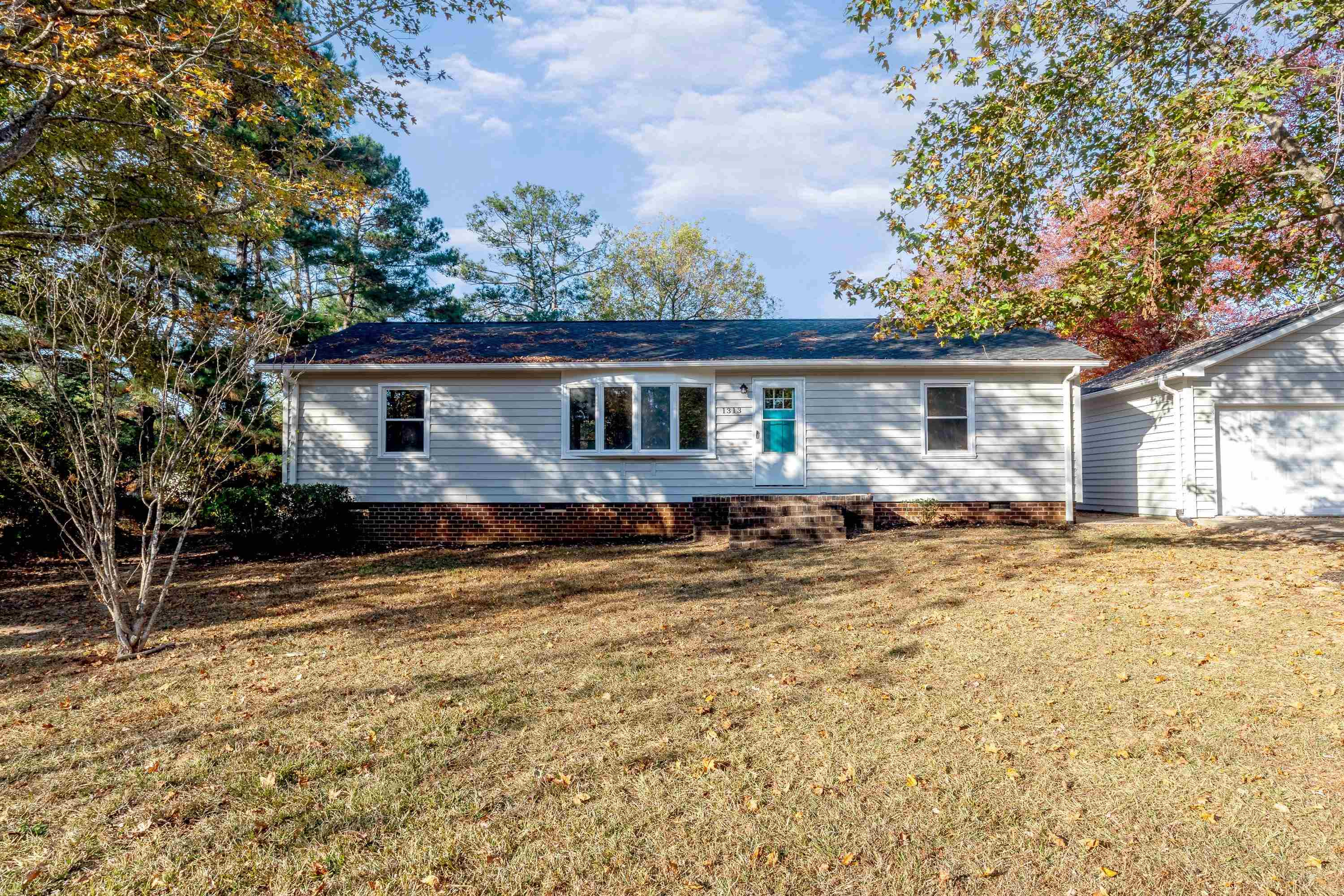 1313 Ewing Drive Garner, NC 27529 - Photo 34 of 46 a view of a house with snow on the wall and trees in the background