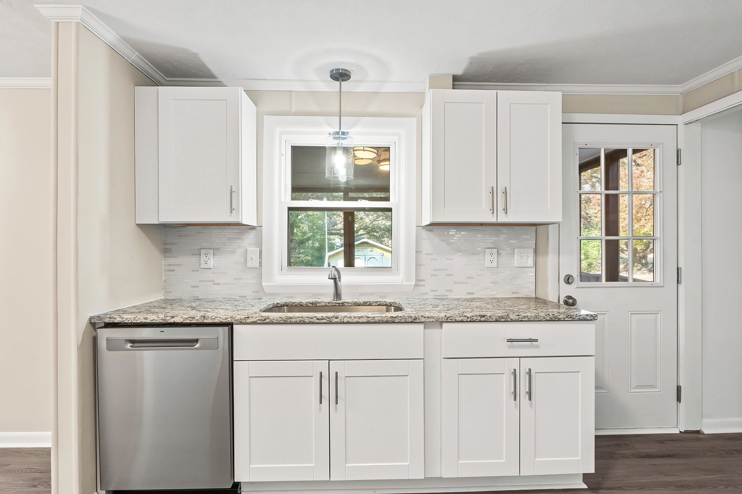 1313 Ewing Drive Garner, NC 27529 - Photo 6 of 46 a kitchen with granite countertop white cabinets and a sink