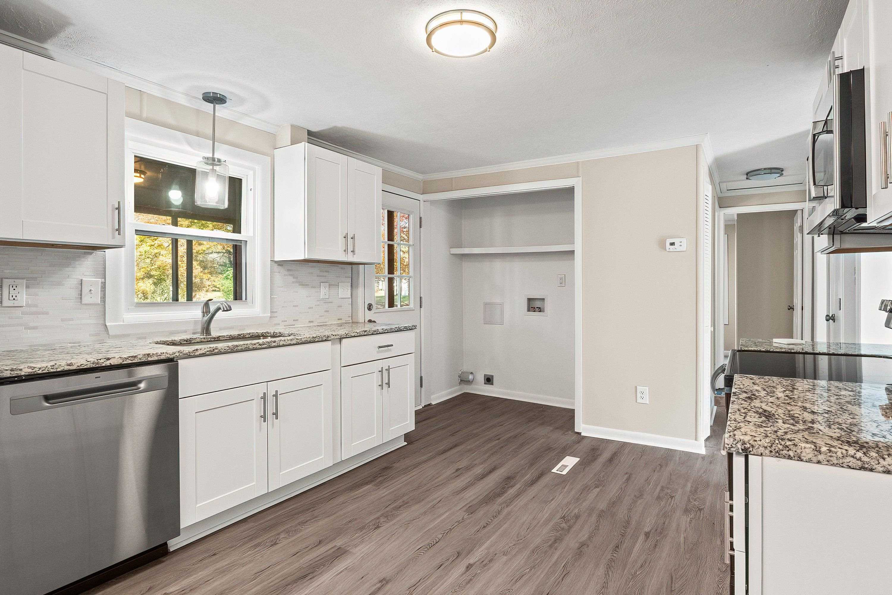 1313 Ewing Drive Garner, NC 27529 - Photo 8 of 46 a kitchen with granite countertop a sink cabinets stainless steel appliances and a counter space