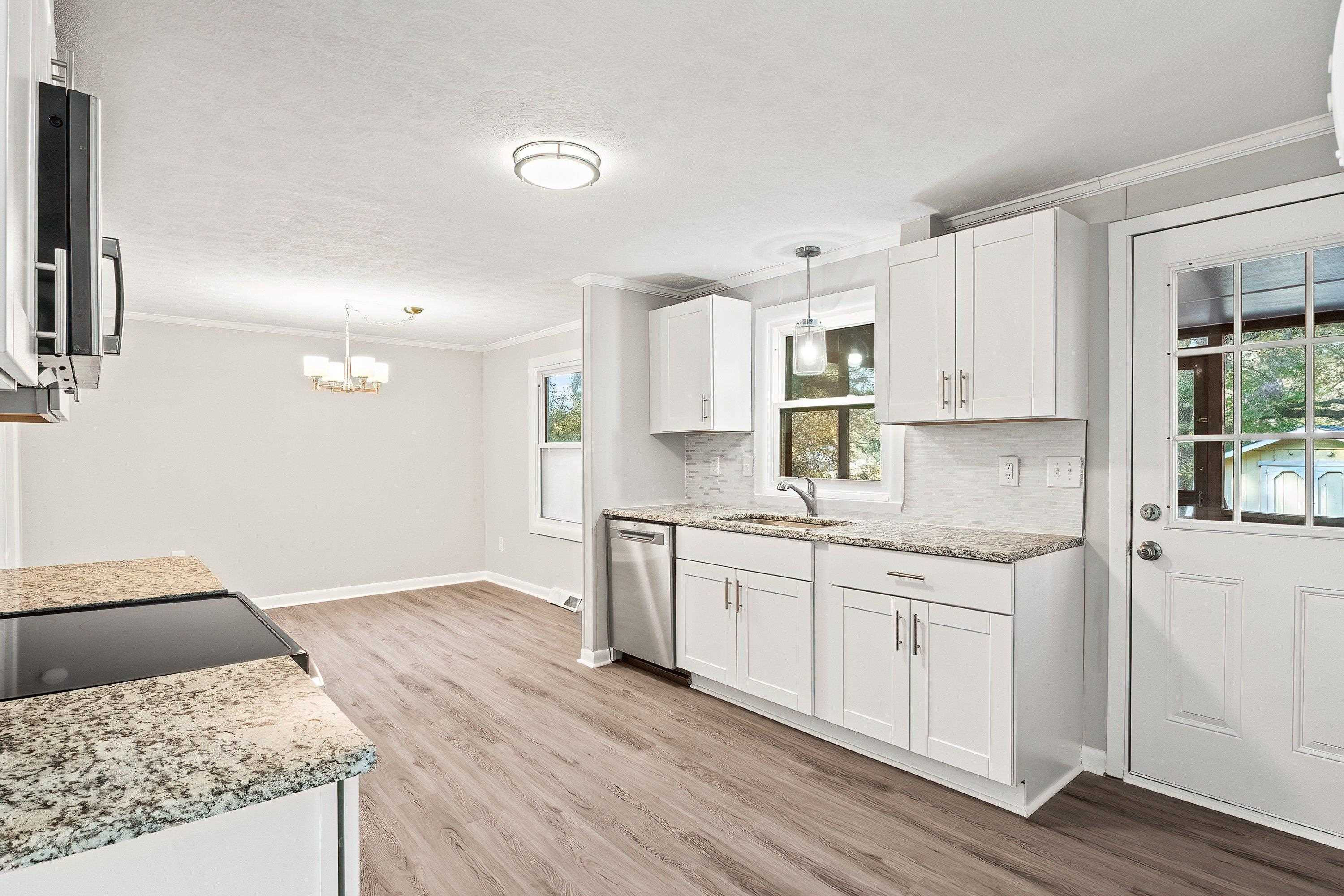 1313 Ewing Drive Garner, NC 27529 - Photo 9 of 46 a kitchen with granite countertop white cabinets and white appliances