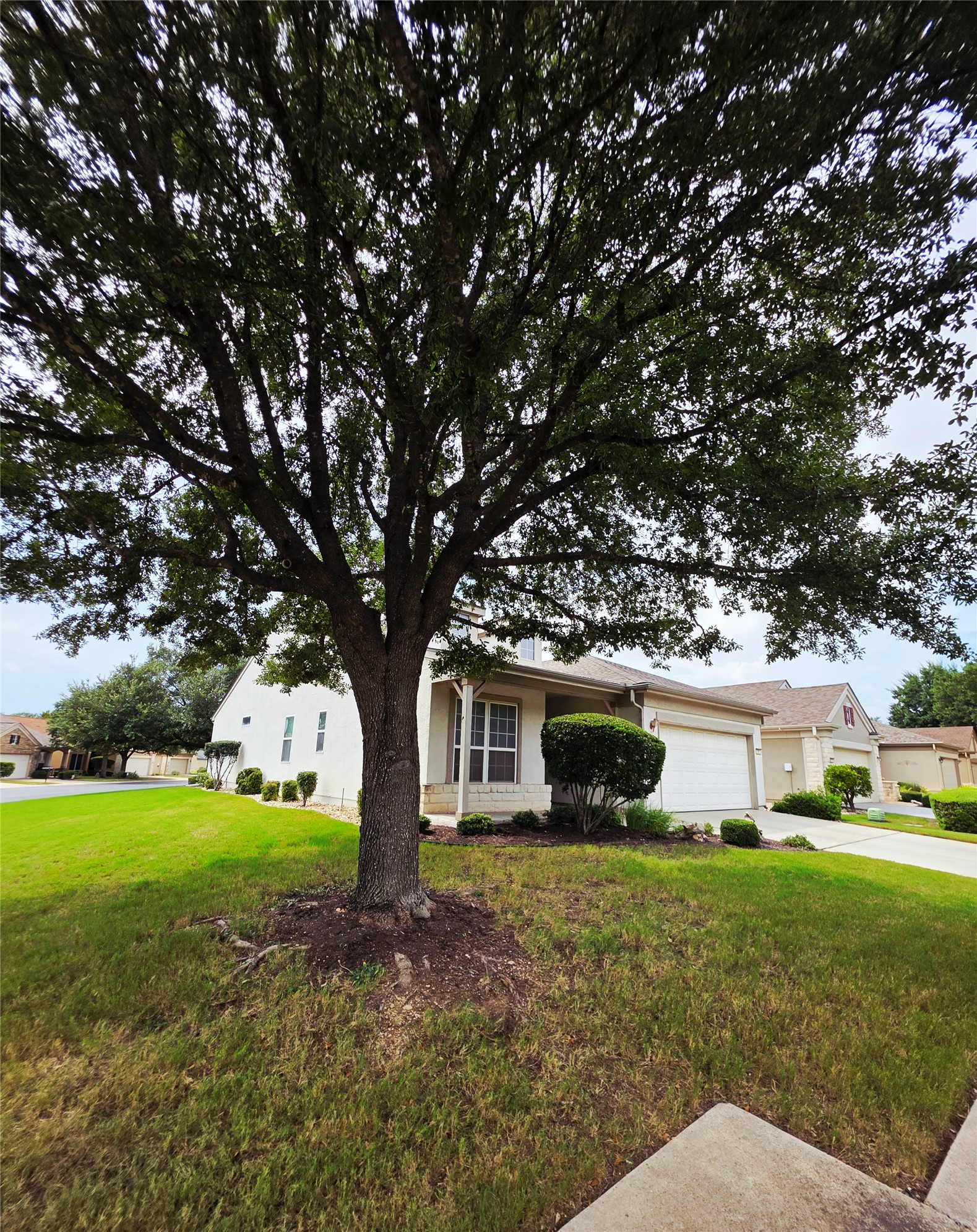 201 Yosemite Road Georgetown, TX 78633 - Photo 1 of 21 View of front facade featuring a front yard, driveway, a garage, covered porch, and stucco siding