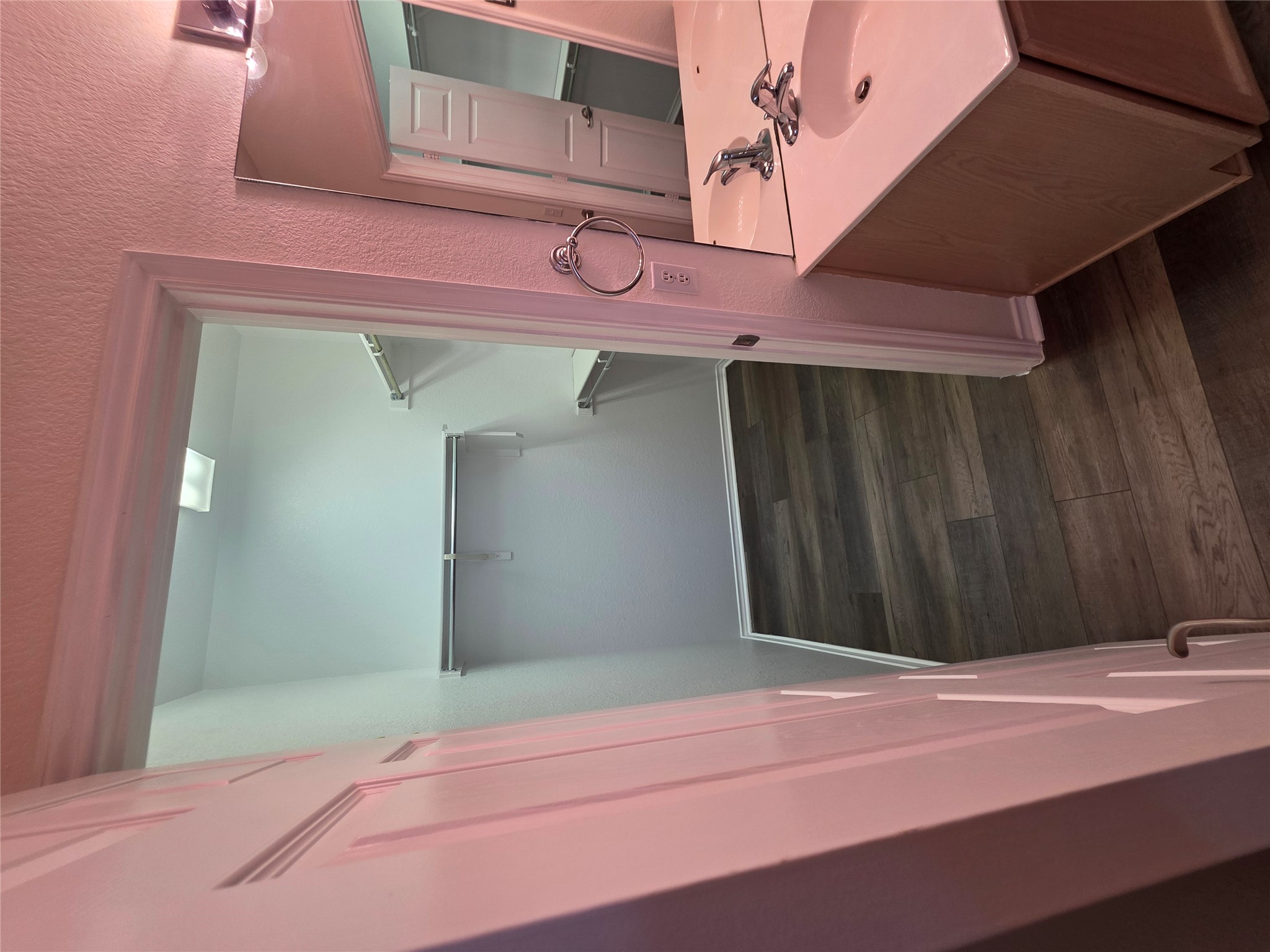 201 Yosemite Road Georgetown, TX 78633 - Photo 12 of 21 Bathroom with a walk in closet, vanity, dark wood-style flooring, and a textured wall