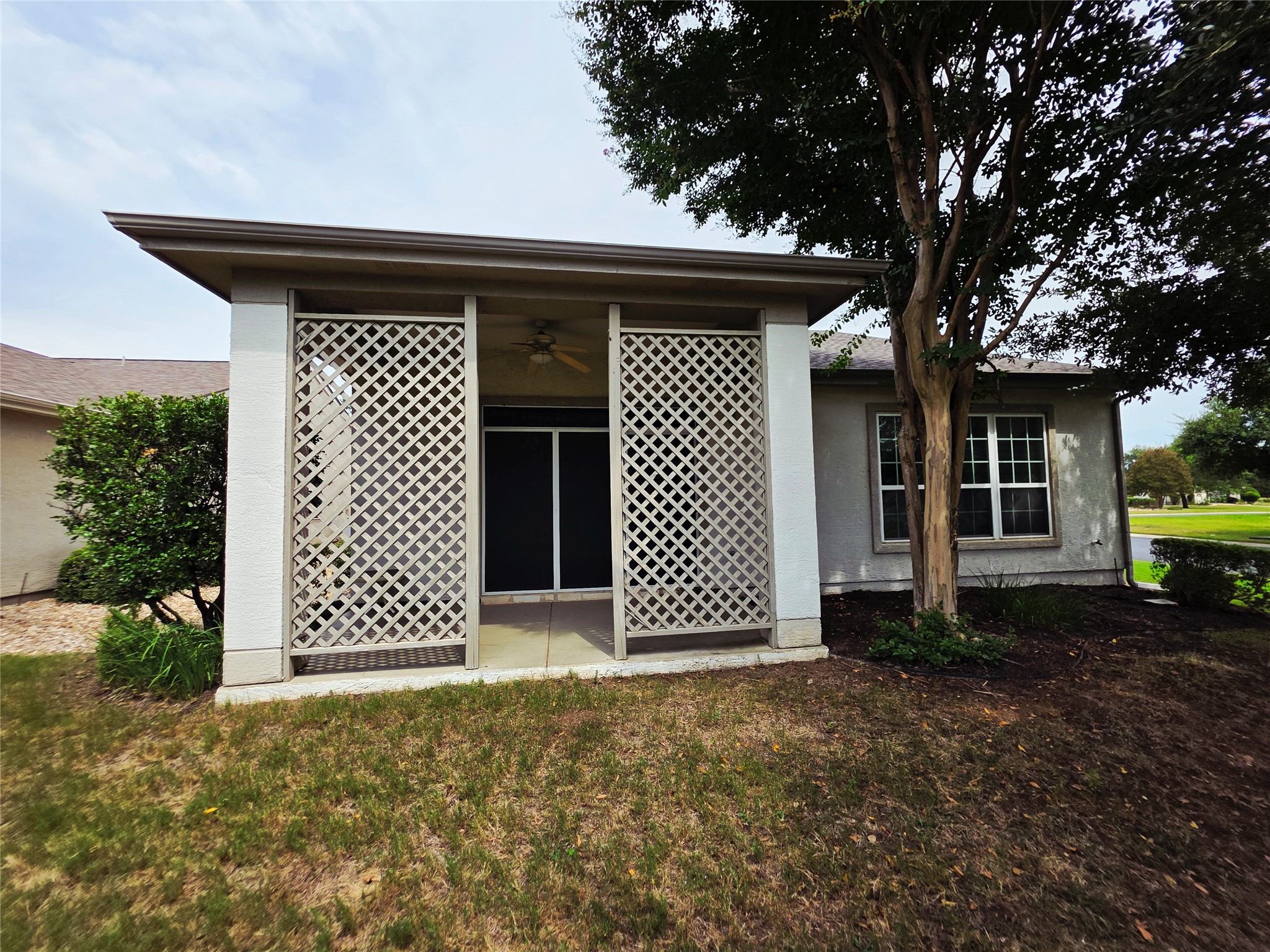 201 Yosemite Road Georgetown, TX 78633 - Photo 4 of 21 Back of property featuring a yard, stucco siding, a patio area, and a ceiling fan