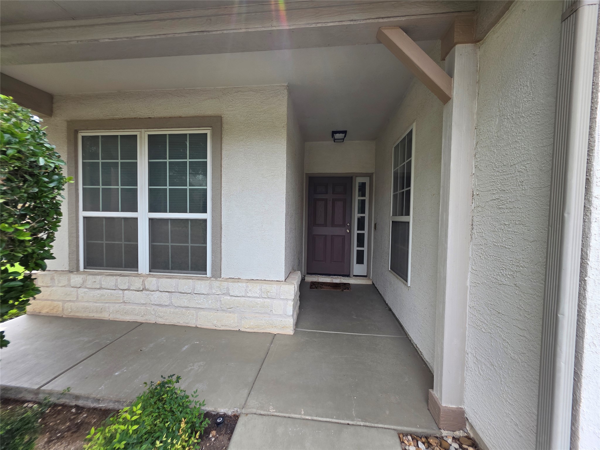 201 Yosemite Road Georgetown, TX 78633 - Photo 6 of 21 View of exterior entry with stucco siding, covered porch, and stone siding