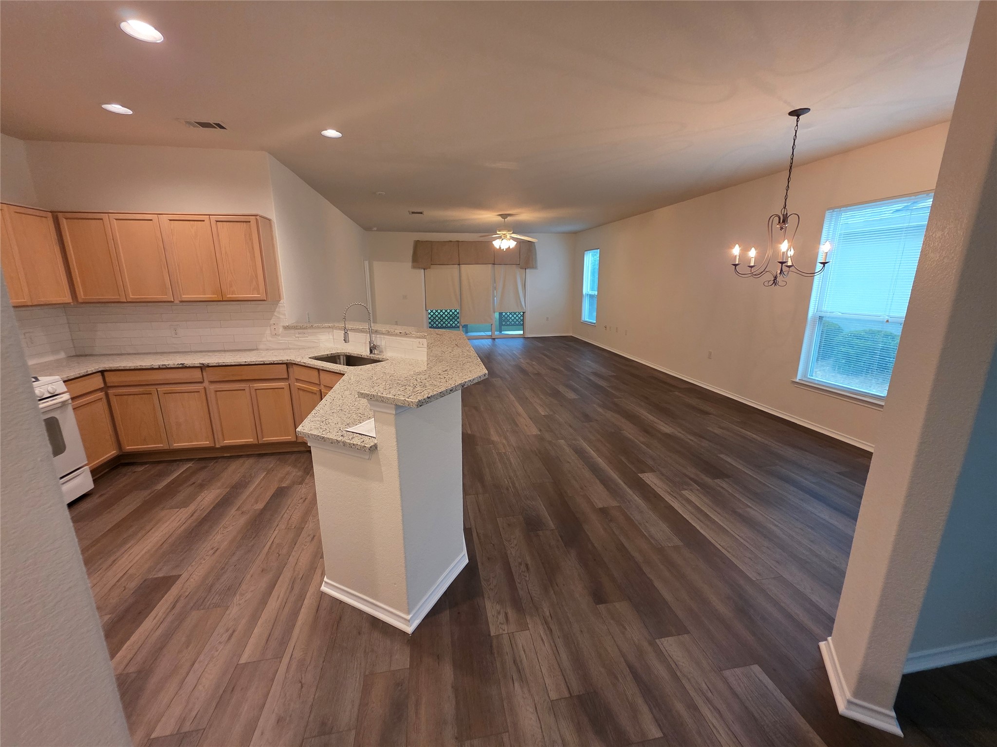 201 Yosemite Road Georgetown, TX 78633 - Photo 21 of 21 Kitchen featuring ceiling fan, open floor plan, tasteful backsplash, light brown cabinets, and white range