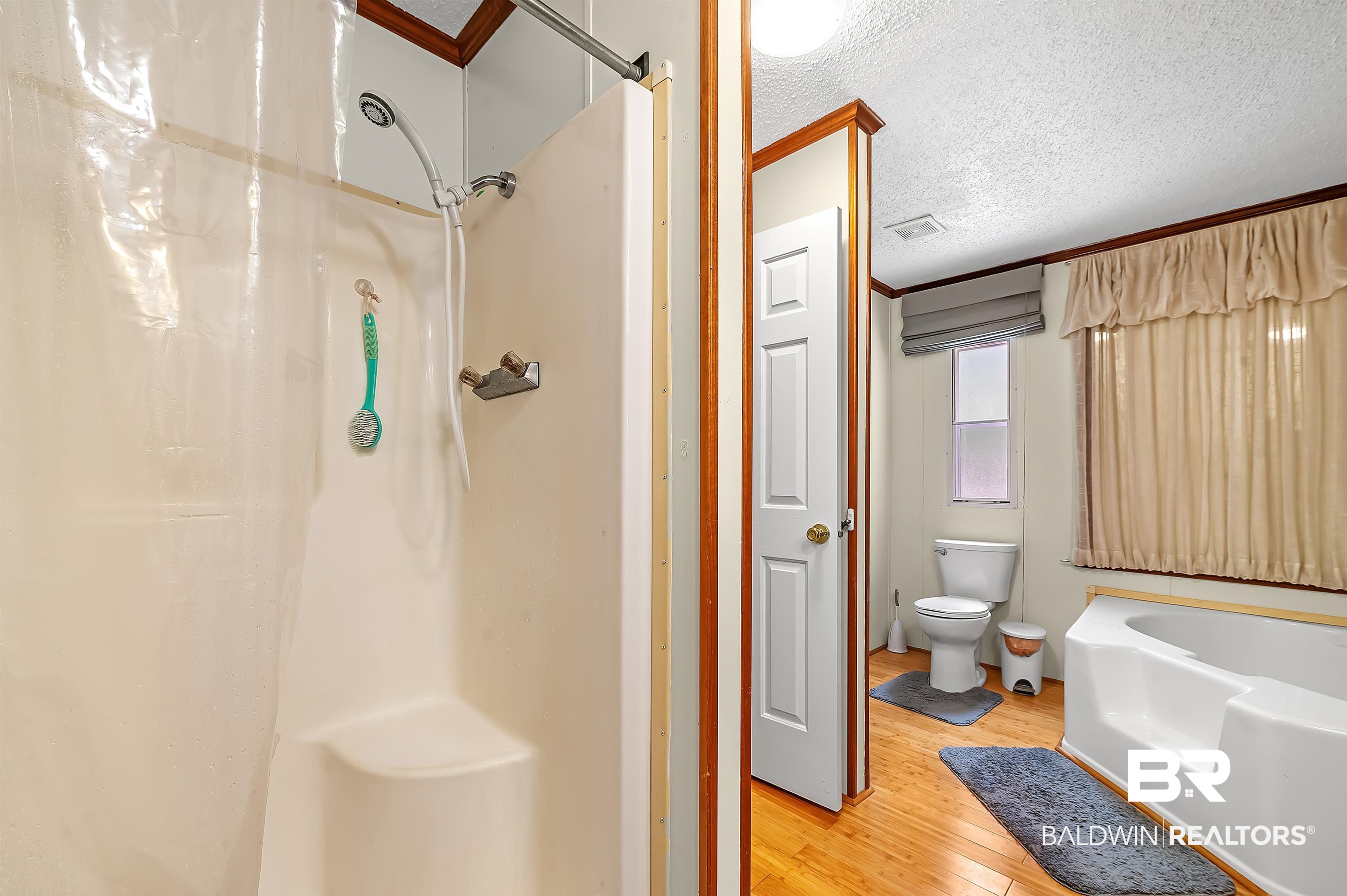 10970 Stucki Road Elberta, AL 36530 - Photo 30 of 56 Bathroom featuring Bamboo floors, crown molding, toilet, and a textured ceiling