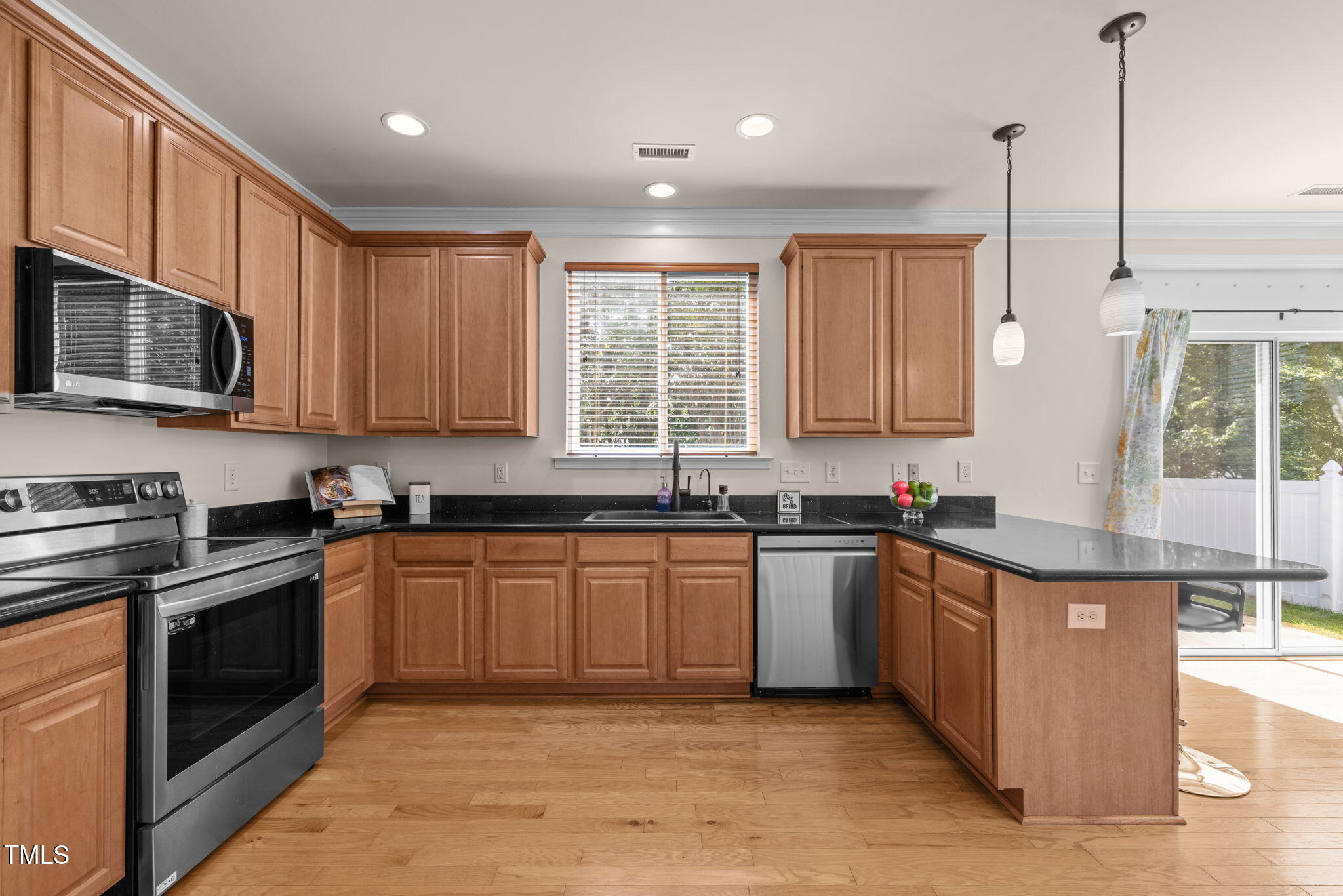 706 Delta Downs Drive Cary, NC 27519 - Photo 15 of 42 a kitchen with stainless steel appliances granite countertop wooden cabinets a sink dishwasher a stove and a refrigerator