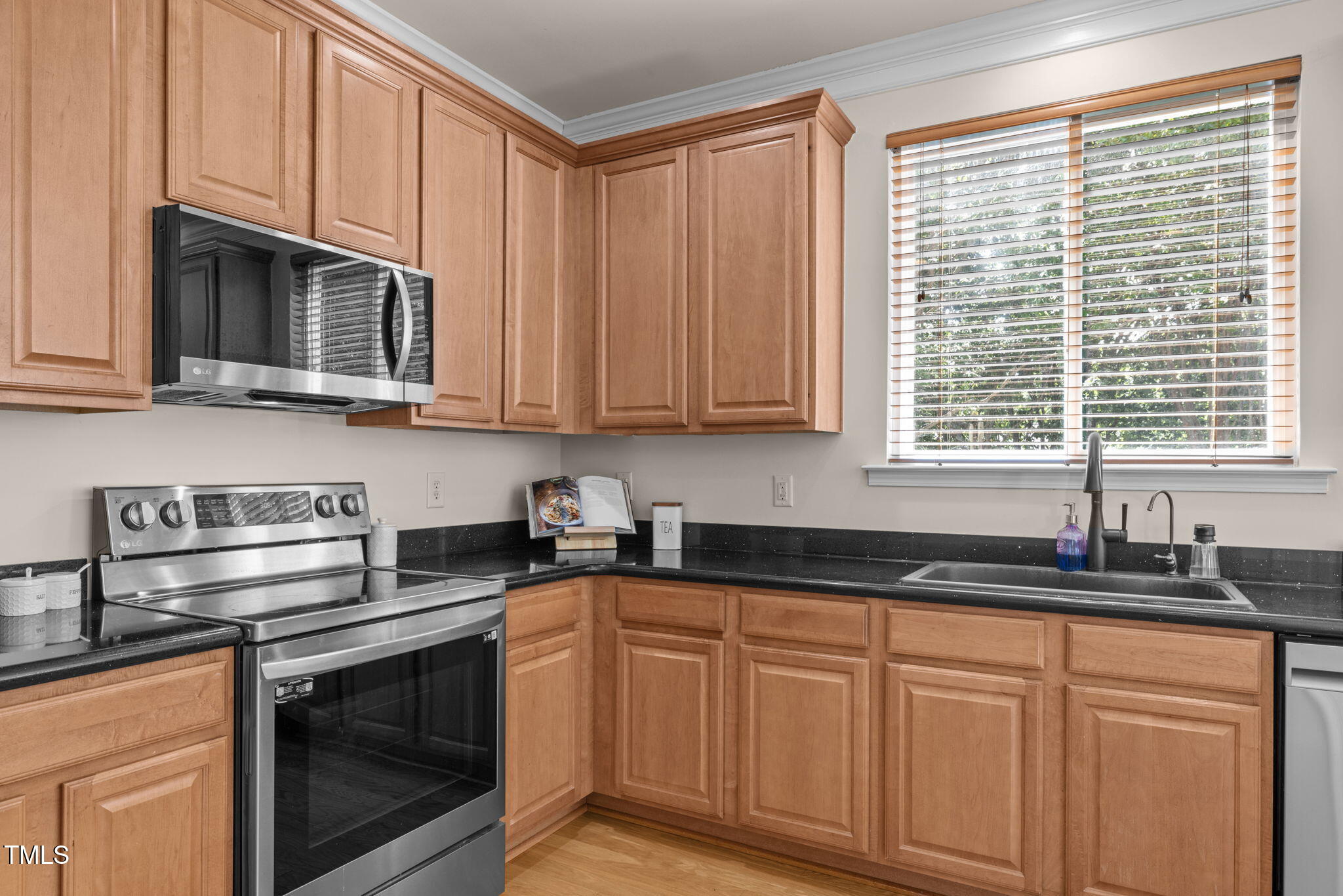 706 Delta Downs Drive Cary, NC 27519 - Photo 16 of 42 a kitchen with granite countertop cabinets stainless steel appliances a sink and a window