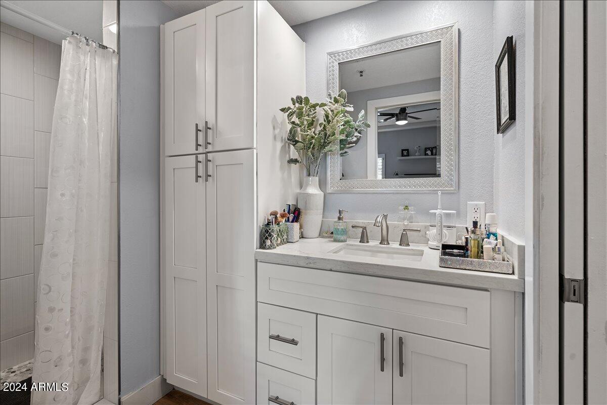 8300 East Vía De Ventura, Unit 1015 Scottsdale, AZ 85258 - Photo 21 of 26 a bathroom with a sink vanity granite and a mirror