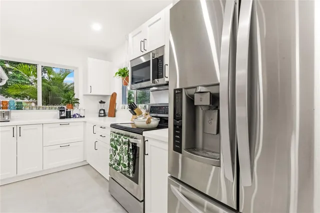 a kitchen with stainless steel appliances granite countertop a refrigerator and a sink