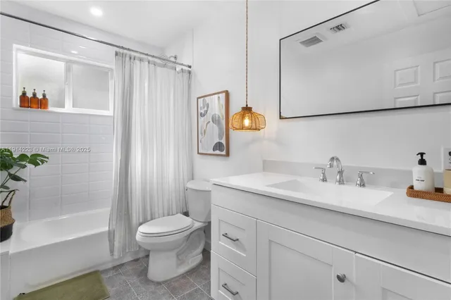 a bathroom with a granite countertop sink toilet a mirror a vanity and shower