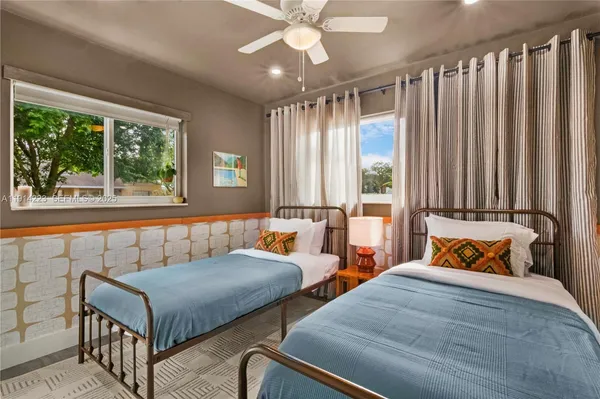 a bedroom with two beds and a large window
