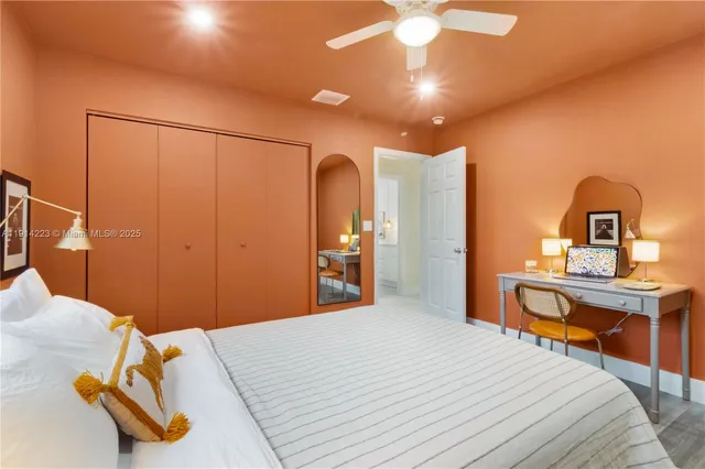 a bedroom with a bed and a table with mirror