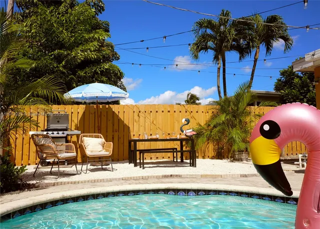 a view of a house with backyard sitting area and swimming pool