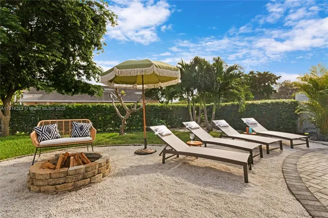 a view of a chairs and table in patio with a small pool