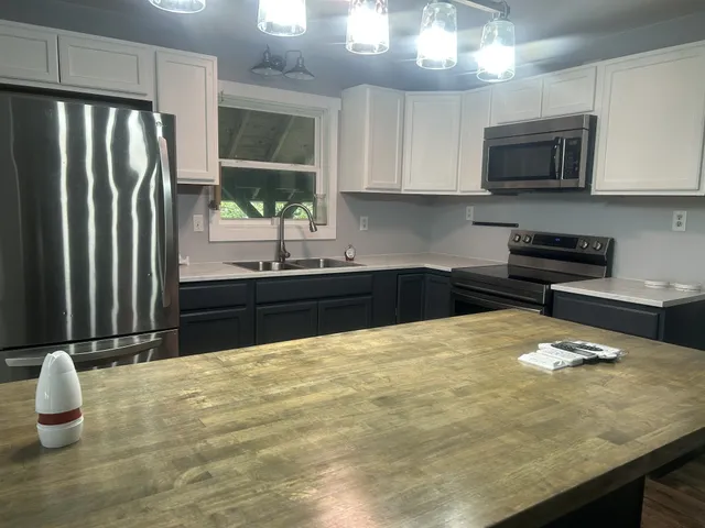 a kitchen with kitchen island a sink stainless steel appliances and cabinets
