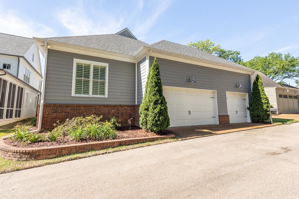 328 Washington Street Collierville, TN 38017 - Photo 31 of 33 Three-car garage with white paneled doors, gray siding, and brick foundation