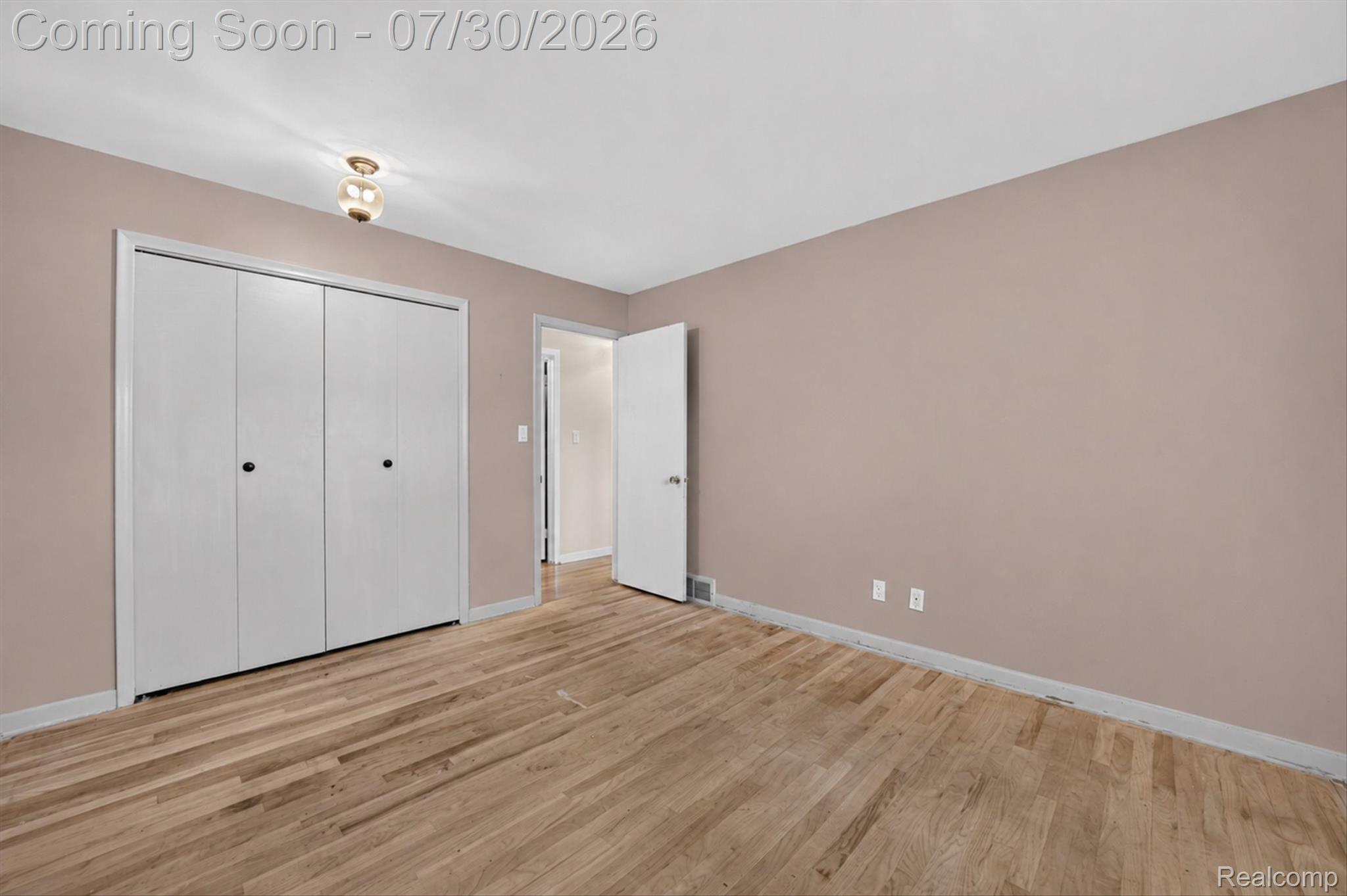 5991 Maybee Road Clarkston, MI 48346 - Photo 16 of 41 Spacious room featuring wood-finish flooring, a bi-fold closet, and a ceiling-mounted light fixture