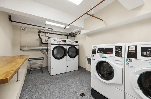 a living room with stainless steel appliances furniture a rug and a window
