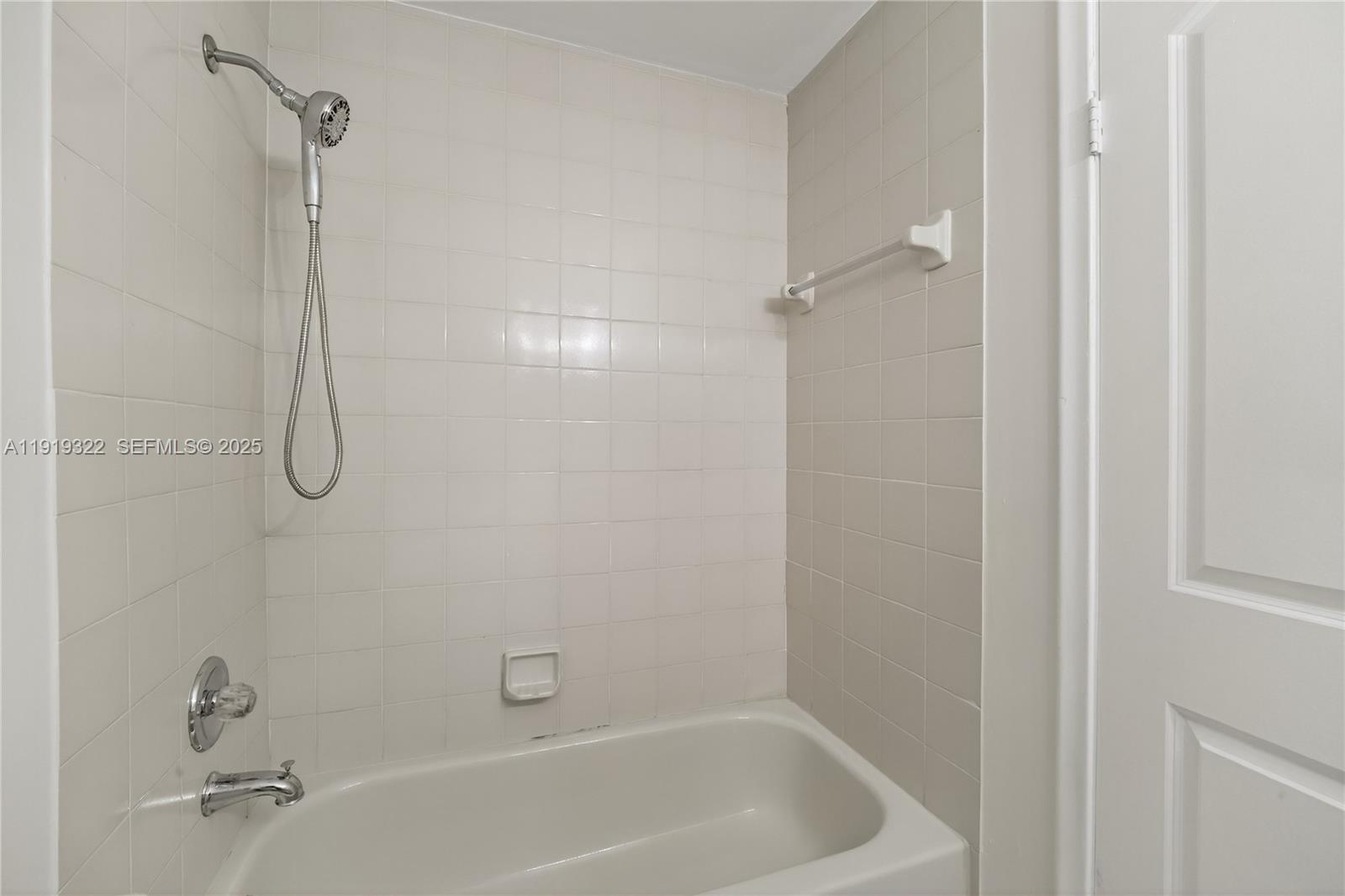 13675 Southwest 62nd Street, Unit 1023 Miami, FL 33183 - Photo 15 of 29 a bathroom with a bath tub with a shower