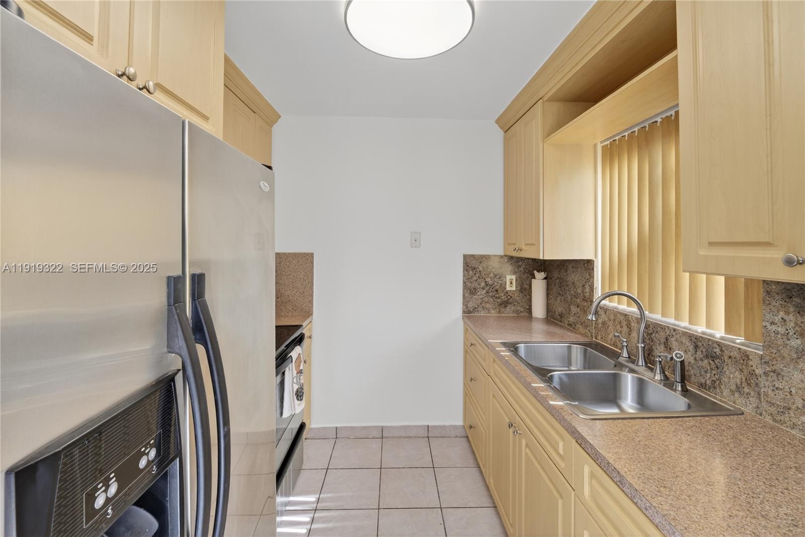 13675 Southwest 62nd Street, Unit 1023 Miami, FL 33183 - Photo 6 of 29 a kitchen with a sink a counter top space and stainless steel appliances