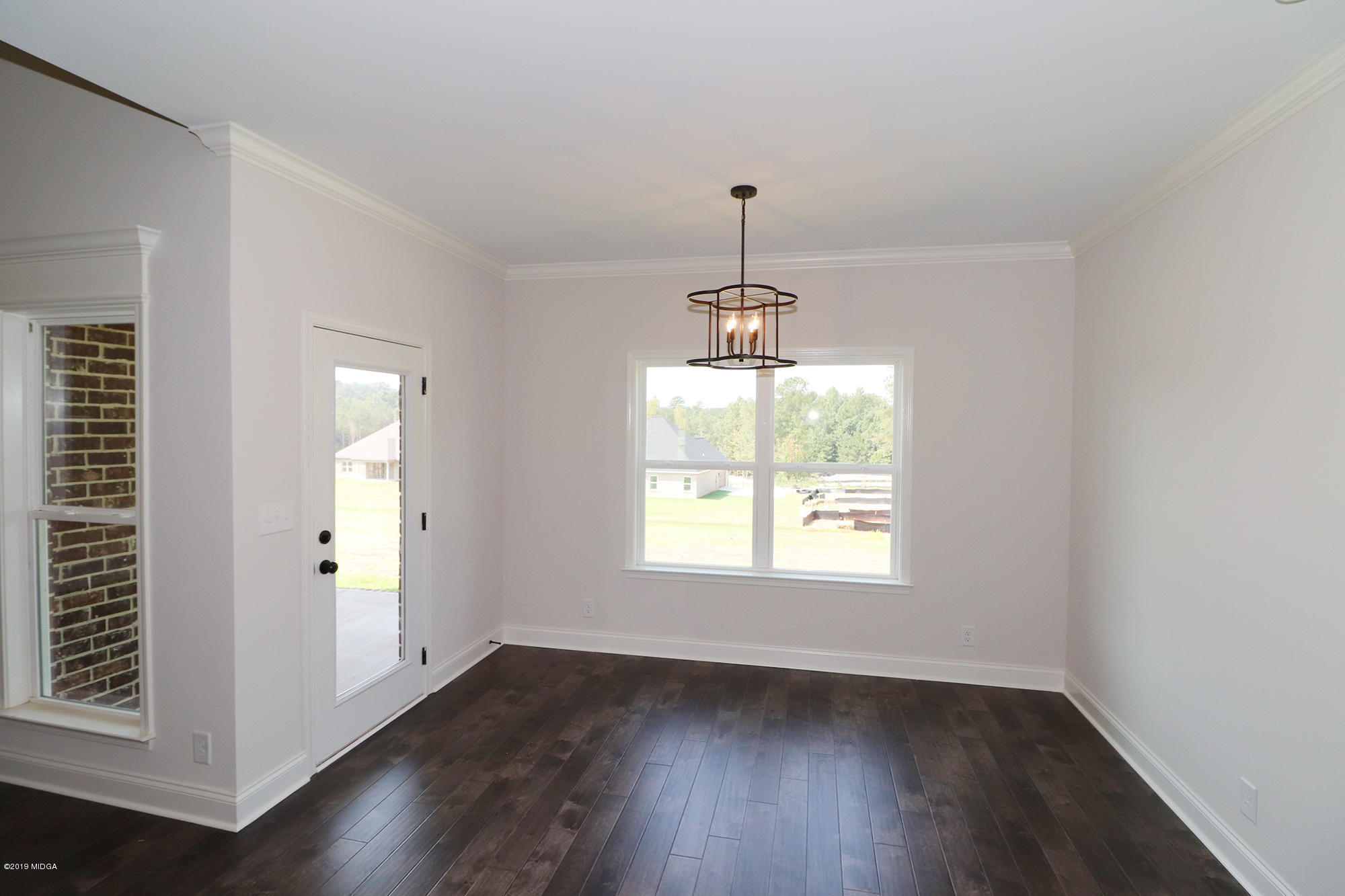 109 Timber Ridge Circle Byron, GA 31008 - Photo 22 of 45 an empty room with wooden floor chandelier and window